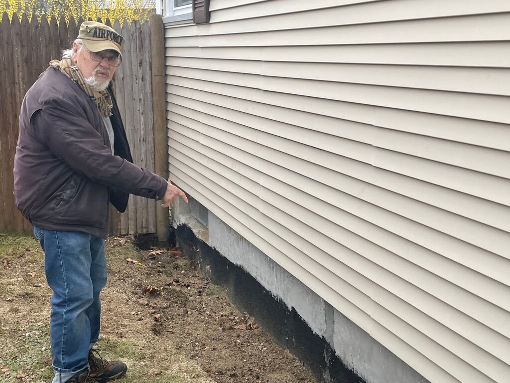 Donald S. Fife points to the place where an Irish contractor dug around the foundation of his home in Warwick, R.I.