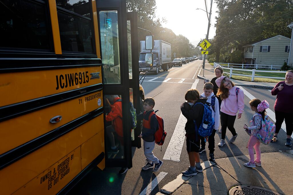 Students board a school bus on Adams Street in East Milton for the morning ride to school in 2023. Milton Public Schools is now facing a projected budget deficit, and a tax override is needed to prevent deeper cuts and layoffs.