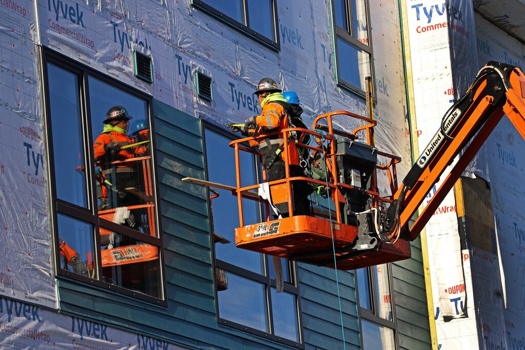 Workers at an apartment building under construction in Revere in 2023.