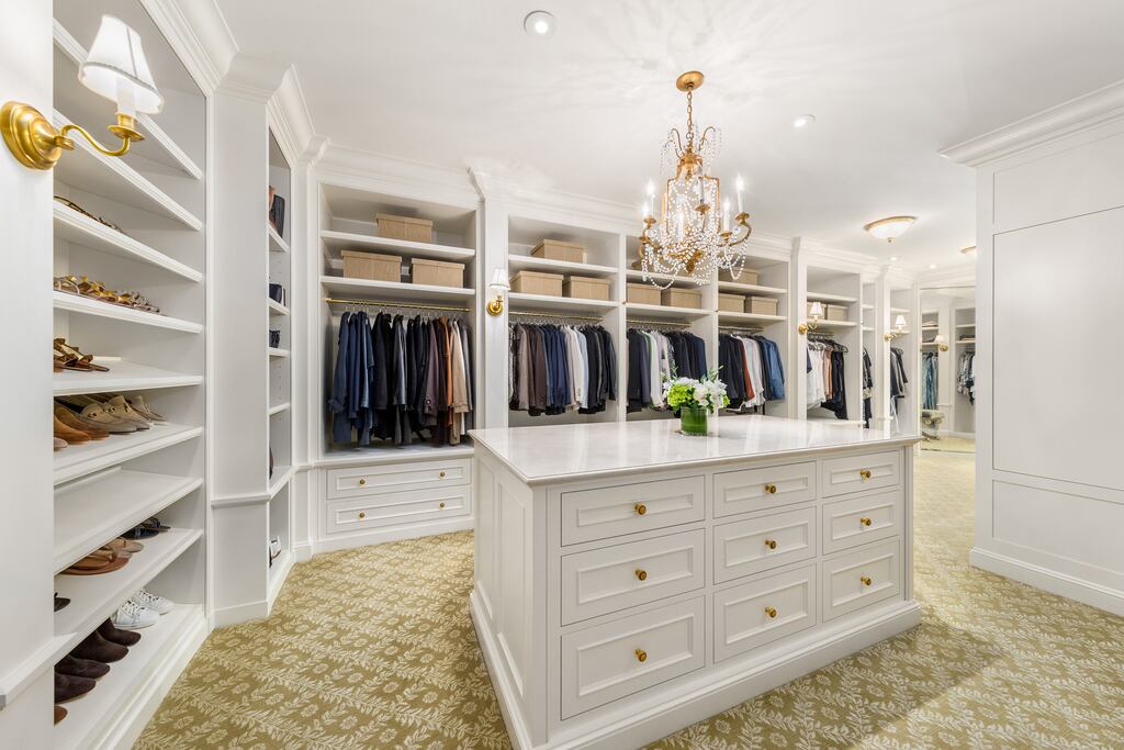 A chandelier illuminates a spacious dressing room.